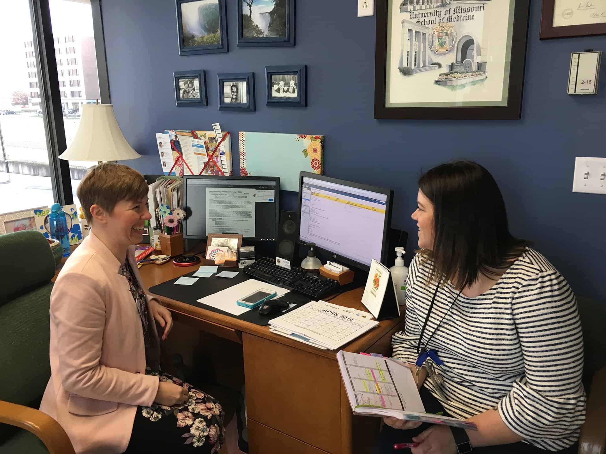Pediatrician Dr. Kelly Wright (left) discusses parenting tactics with Amanda Coleman, a parent educator in the Springfield Parents as Teachers home visiting program. Coleman is embedded in the clinical setting at Cox North Pediatrics.