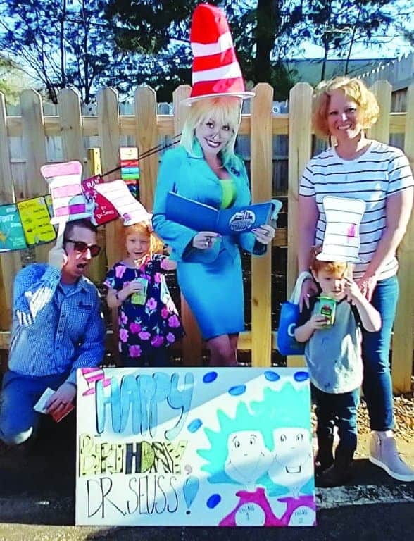 Families pose with a cardboard cutout of Dolly Parton at an event celebrating the completion of an outdoor learning environment at Smart Start of Davie Parents as Teachers affiliate.