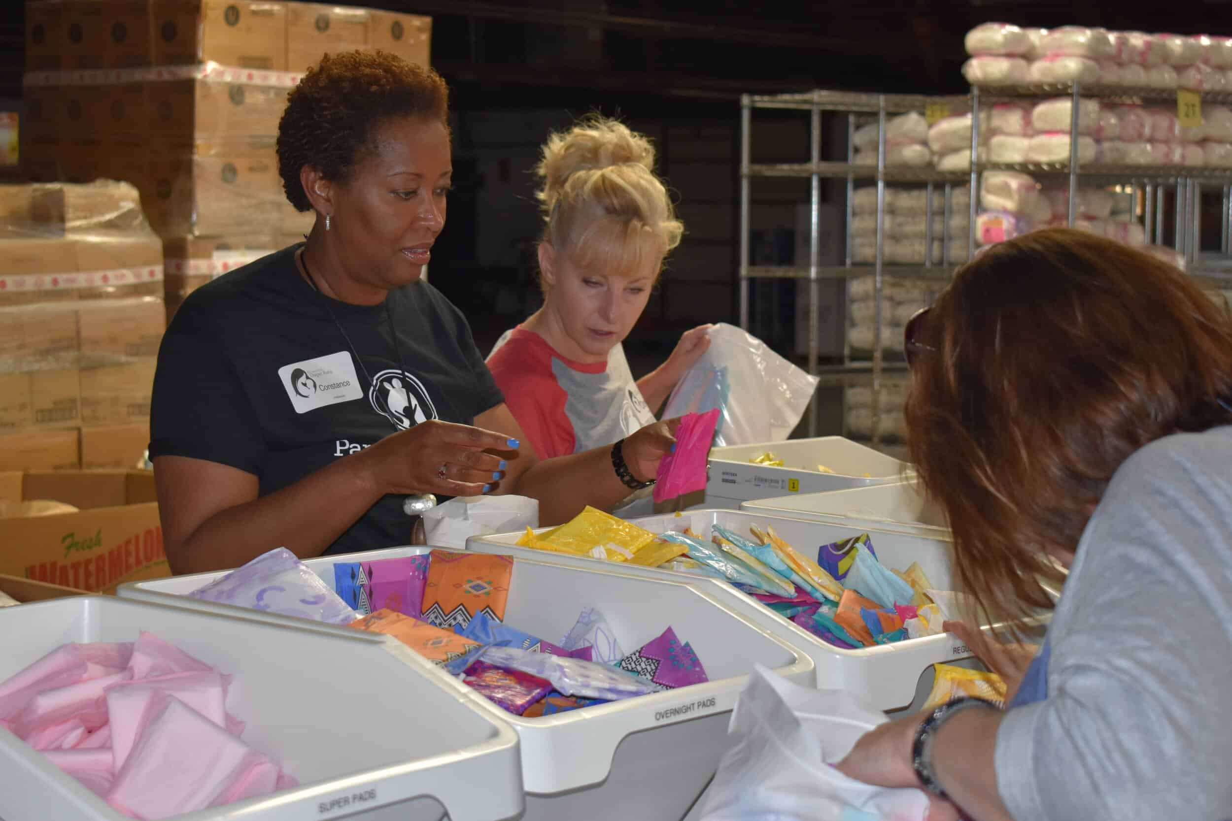 At left: Parents as Teachers President/CEO Constance Gully and Donna O’Brien VP, professional and program development, and Kerry Caverly, PAT senior VP, chief program officer, prepare feminine hygiene product kits for distribution to area low-income…