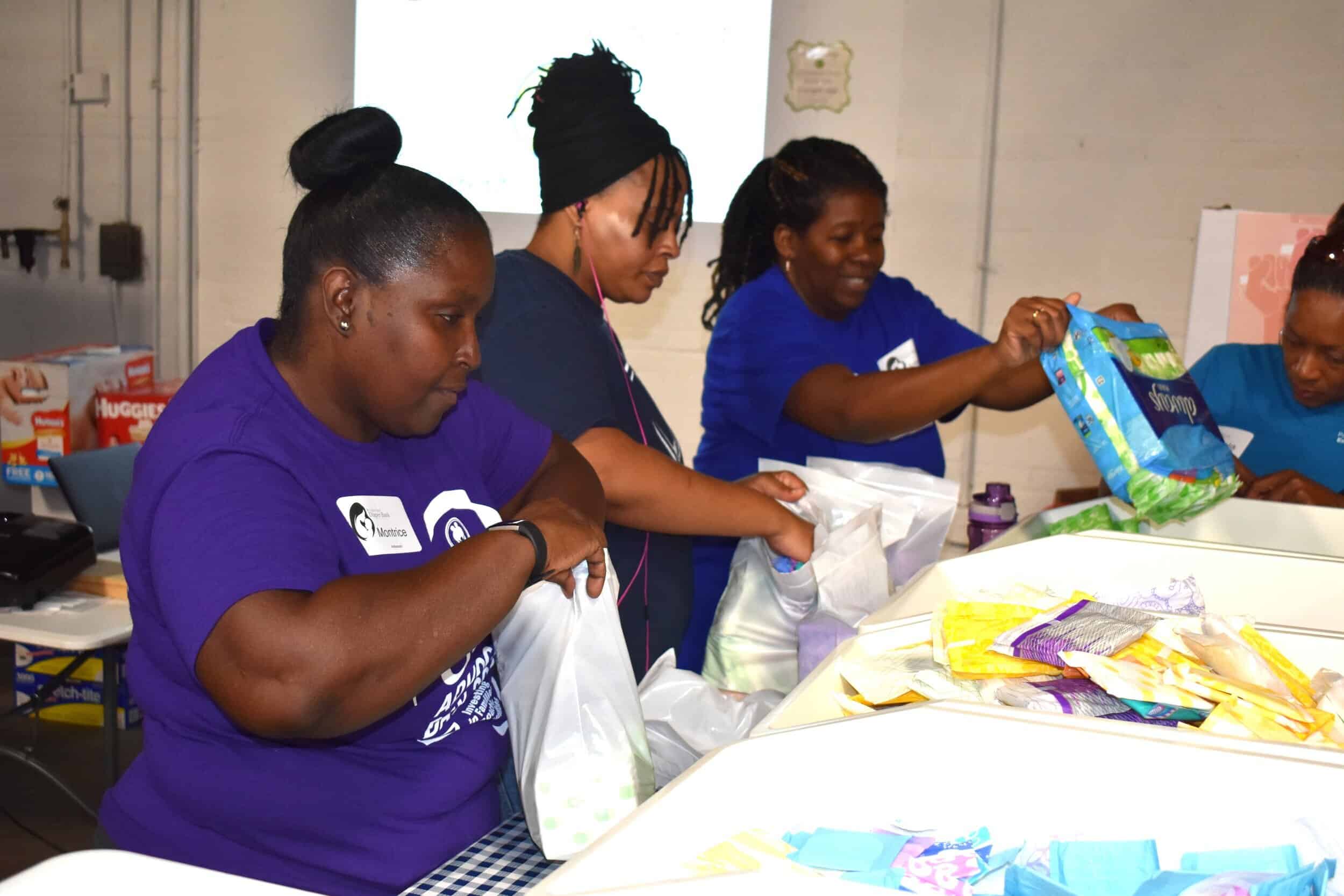 From left: Parents as Teacher staffers Montrice Humphrey, Carmen Qualls, Antionette Becerra, and Angela Gardner prepare feminine hygiene product kits for distribution to area low-income women at the St. Louis Diaper Bank as part of PAT’s giving back…